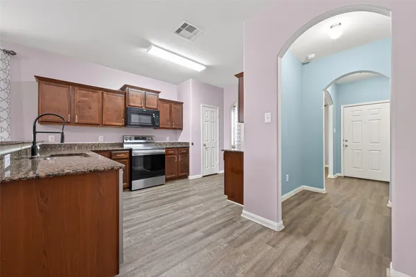 a kitchen with stainless steel appliances granite countertop a stove a sink and a refrigerator