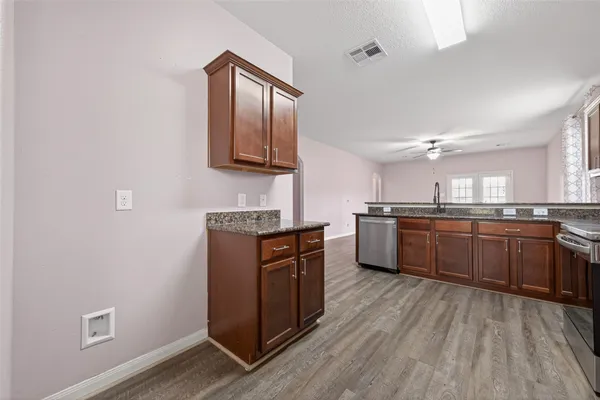 a kitchen with stainless steel appliances sink a stove and cabinets