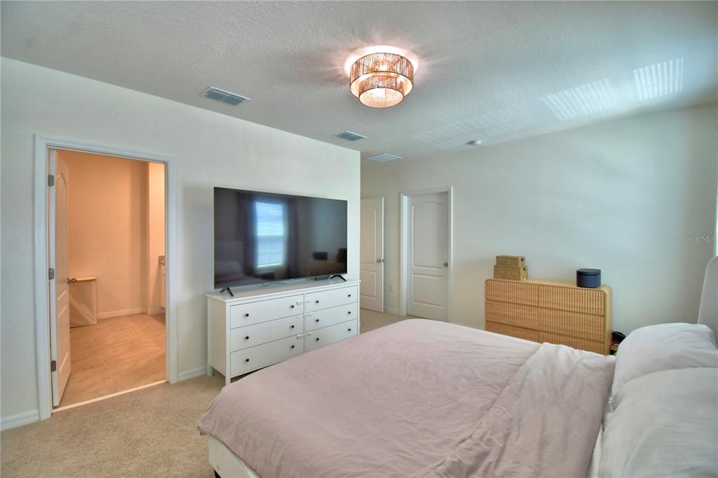 2839 Moulin Road Davenport, FL 33837 - Photo 33 of 75 a bedroom with a bed and a flat screen tv