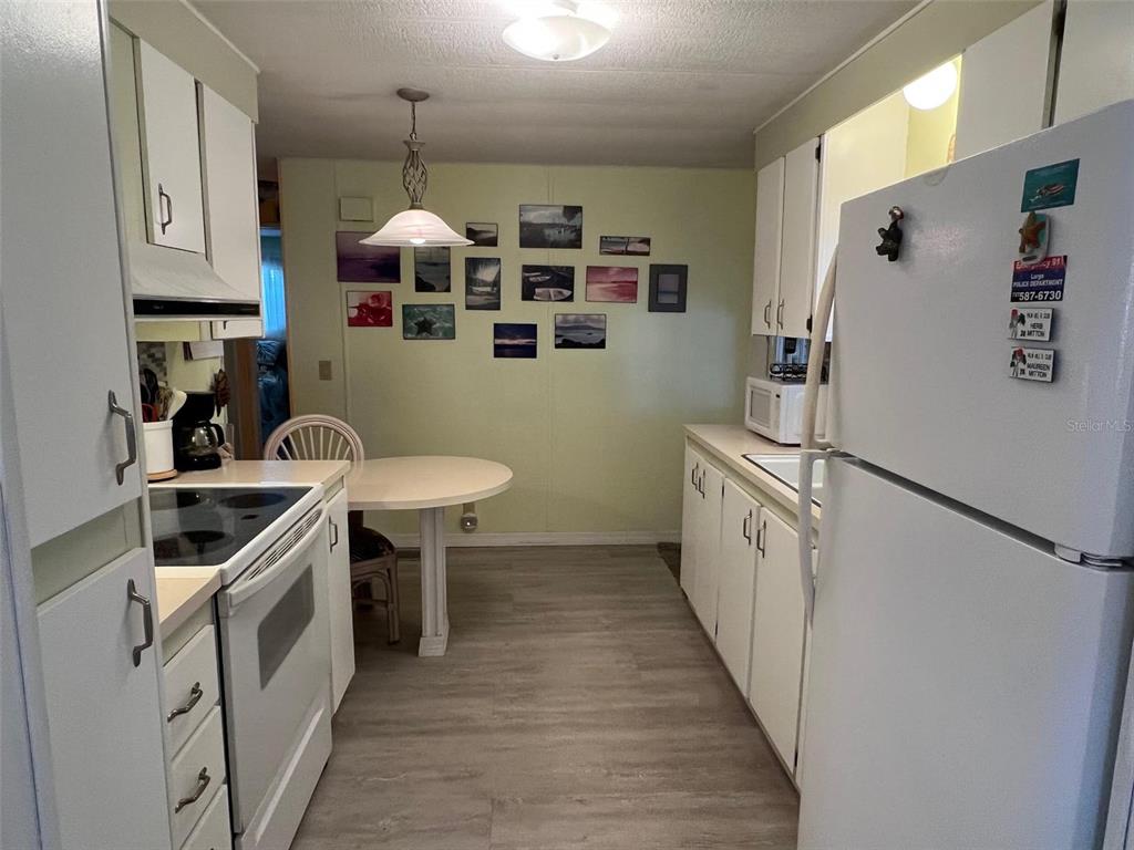 52 Frangipani Circle Largo, FL 33770 - Photo 7 of 33 a kitchen with white cabinets and white appliances