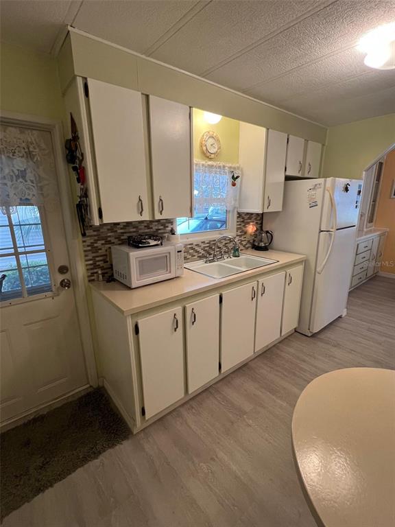 52 Frangipani Circle Largo, FL 33770 - Photo 9 of 33 a kitchen with stainless steel appliances a sink cabinets and wooden floor