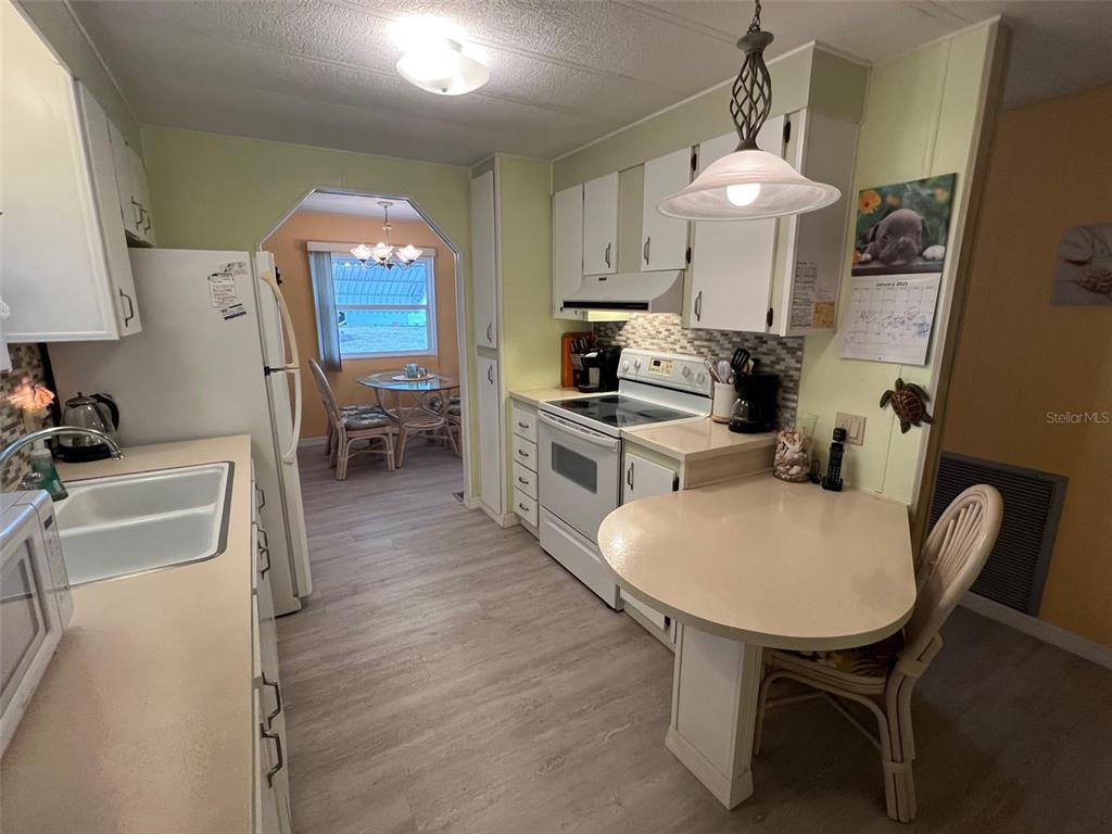 52 Frangipani Circle Largo, FL 33770 - Photo 10 of 33 a kitchen with stainless steel appliances a sink a stove a refrigerator cabinets and furniture