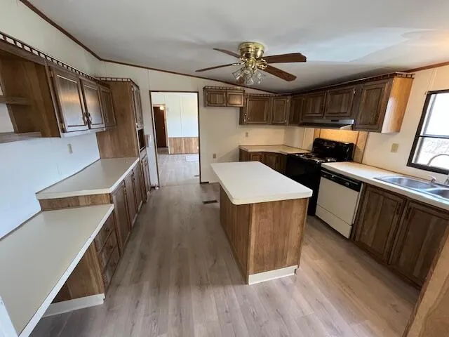 a kitchen view with wooden floor and stainless steel appliances