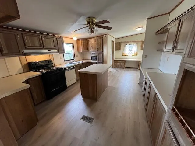 a kitchen with sink a counter top space appliances and cabinets