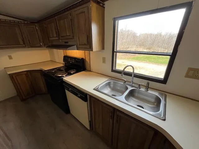 a kitchen with granite countertop a sink and a stove