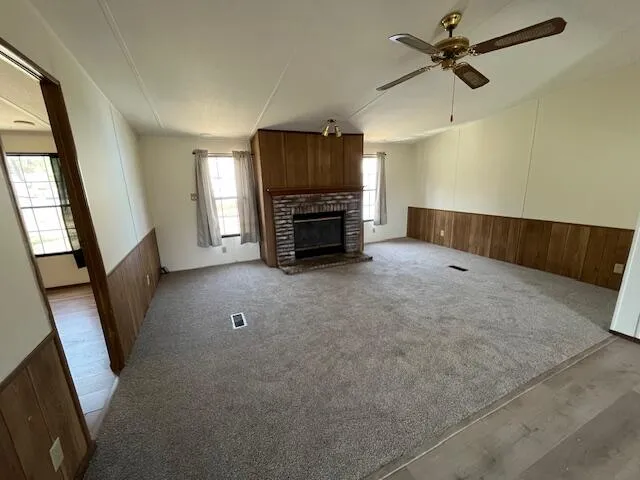 a view of an empty room with a fireplace and a window
