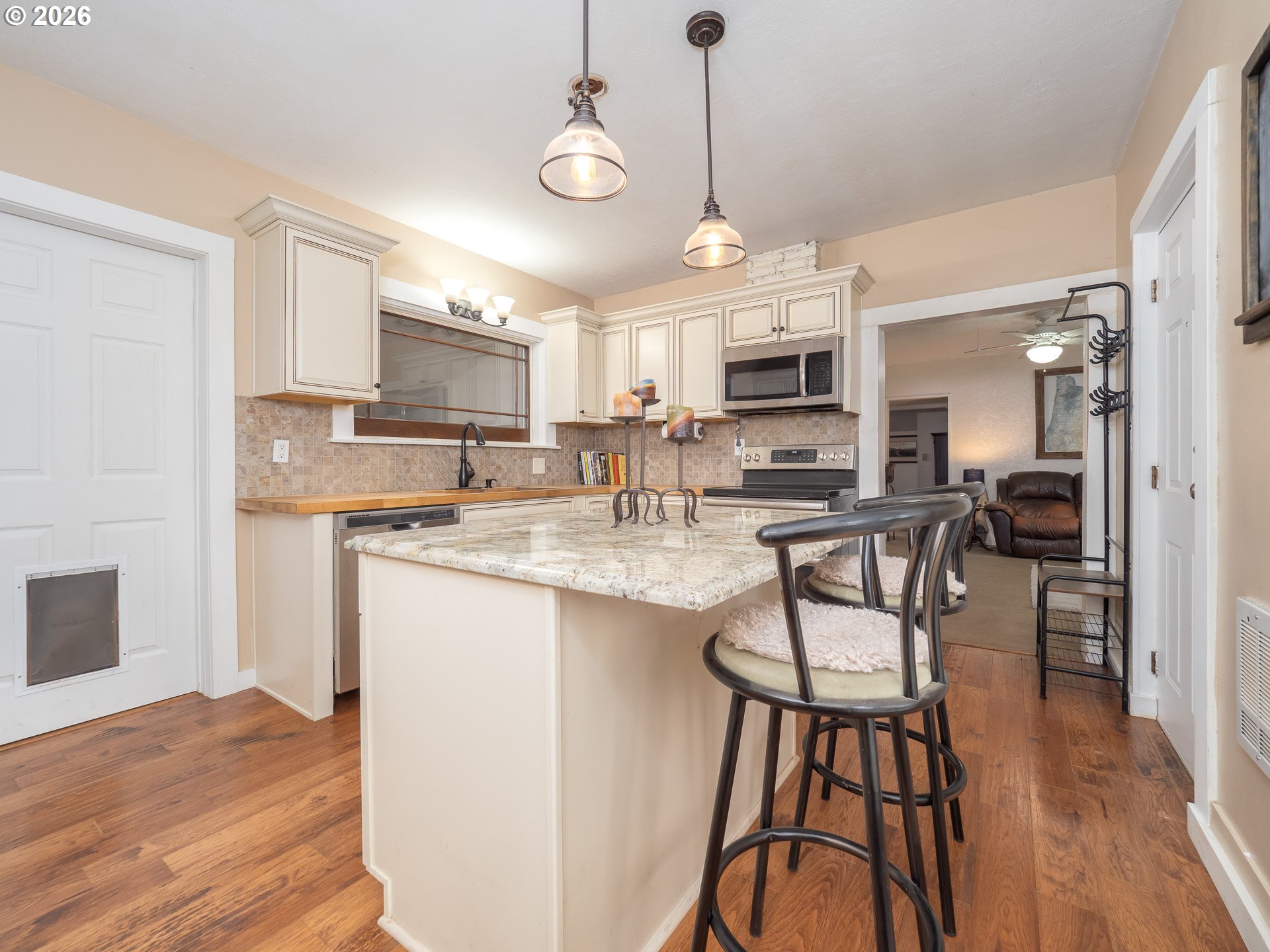 336 North 5th Street Carlton, OR 97111 - Photo 7 of 48 a kitchen with stainless steel appliances granite countertop a stove top oven a sink a dining table and chairs with wooden floor