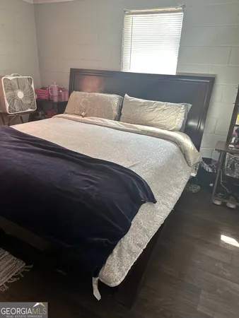 a bedroom with a bed purple white bedspread and pillows