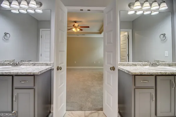 a bathroom with a granite countertop sink a light fixture and a mirror