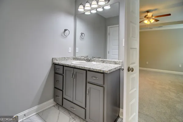 a bathroom with a sink a light fixture and a mirror