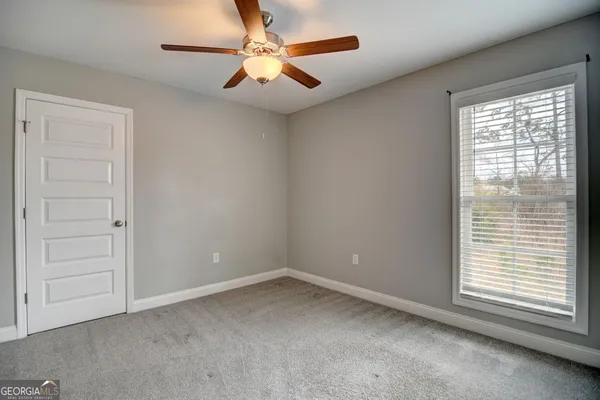an empty room with a window and a fan