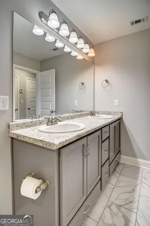 a bathroom with a granite countertop sink a large mirror and vanity