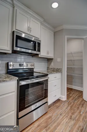 a kitchen with stainless steel appliances granite countertop a stove microwave and oven
