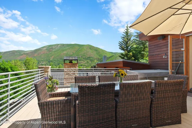 a view of a balcony with two chairs and a barbeque
