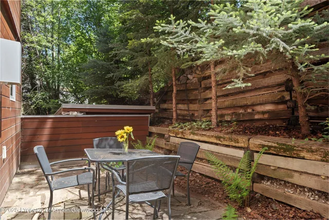 a view of a chairs and table in a back yard