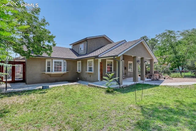 a front view of a house with a yard and outdoor seating