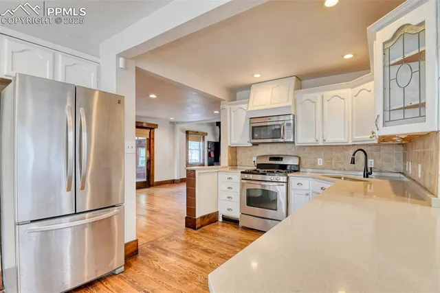 a kitchen with stainless steel appliances granite countertop a refrigerator sink and stove