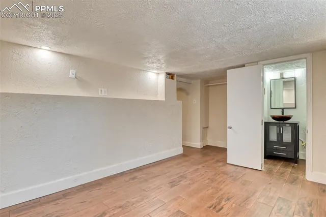 a view of an empty room with chandelier fan and fire place