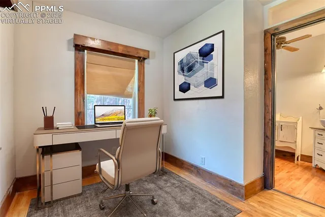 a view of a workspace with furniture and a window