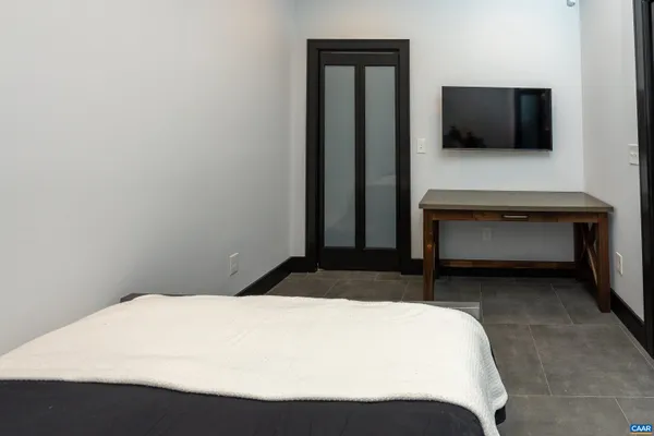 a bedroom with a bed and a flat screen tv