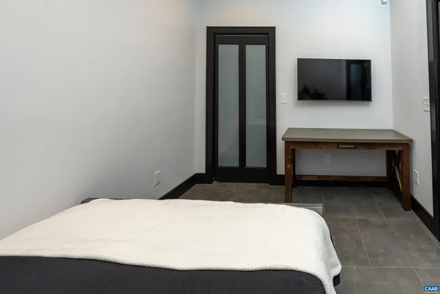 a bedroom with a bed and a flat screen tv