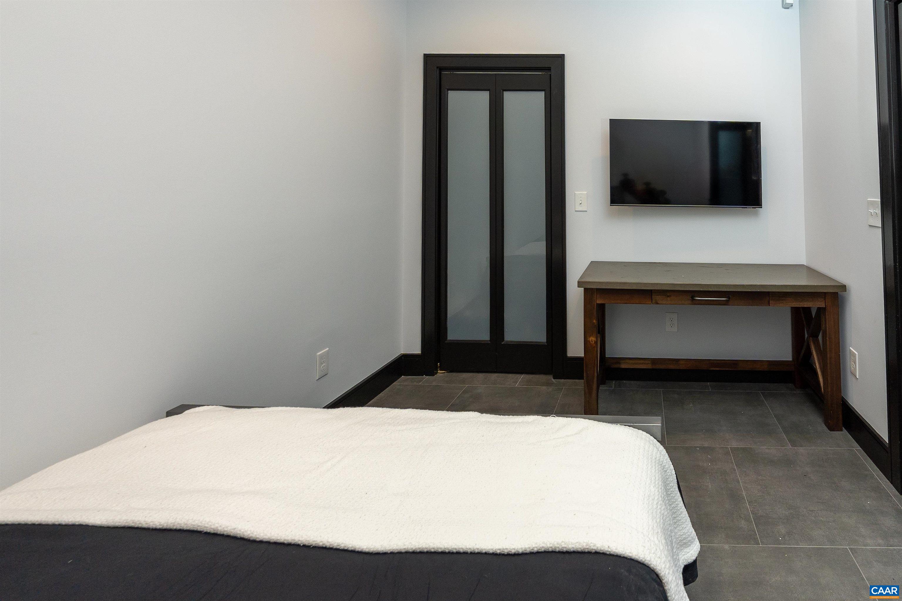 218 West Water Street, Unit 600 Charlottesville, VA 22902 - Photo 20 of 40 a bedroom with a bed and a flat screen tv