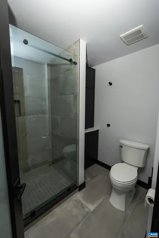 a bathroom with a toilet and a shower