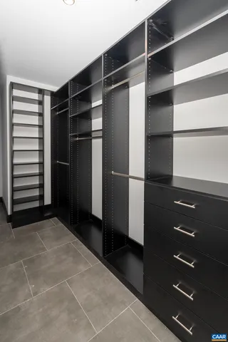 a view of walk in closet with empty racks