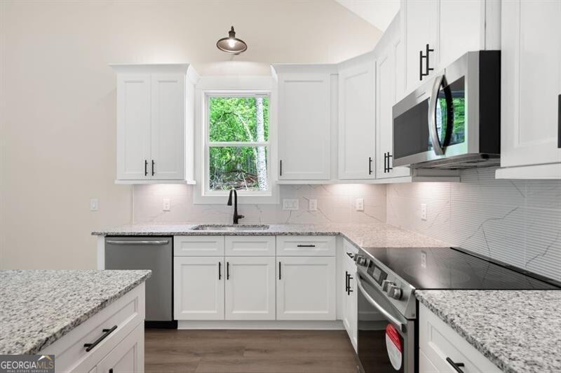 110 Doris Path Dallas, GA 30157 - Photo 12 of 35 a kitchen with stainless steel appliances granite countertop a sink stove and cabinets