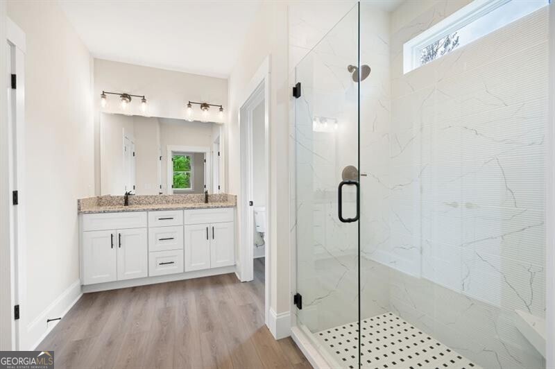 110 Doris Path Dallas, GA 30157 - Photo 19 of 35 a spacious bathroom with a granite countertop sink a mirror a vanity and a shower