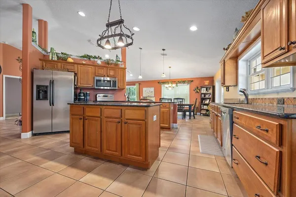 a kitchen with stainless steel appliances granite countertop a stove a sink a oven and a refrigerator