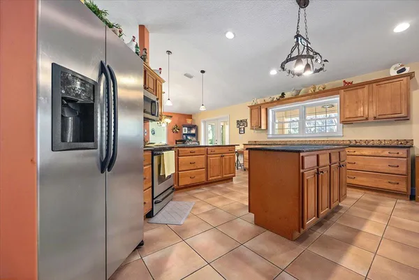 a kitchen with stainless steel appliances granite countertop a refrigerator and a stove