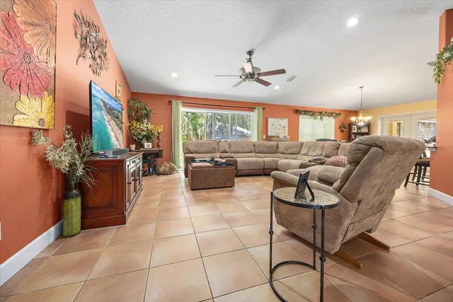 a living room with furniture a chandelier and a floor to ceiling window