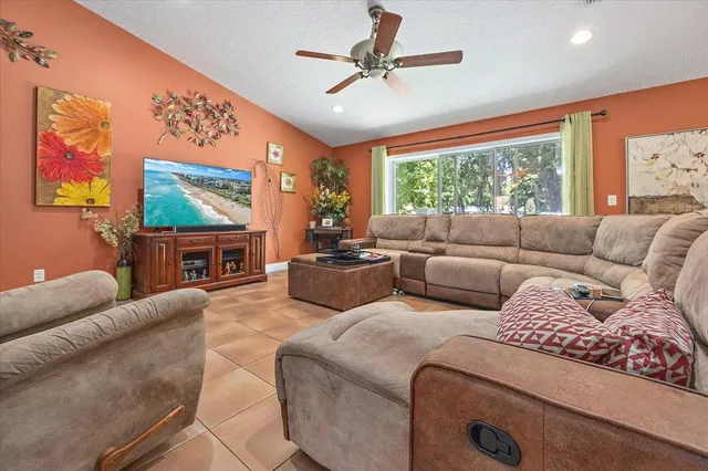 a living room with furniture a large window with a flat screen tv