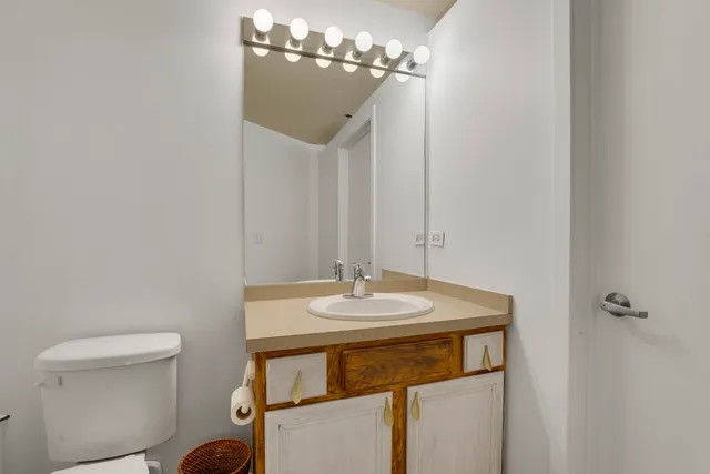 a bathroom with a sink a toilet and a mirror