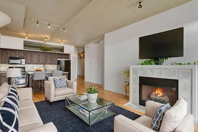 a living room with furniture a flat screen tv and a fireplace