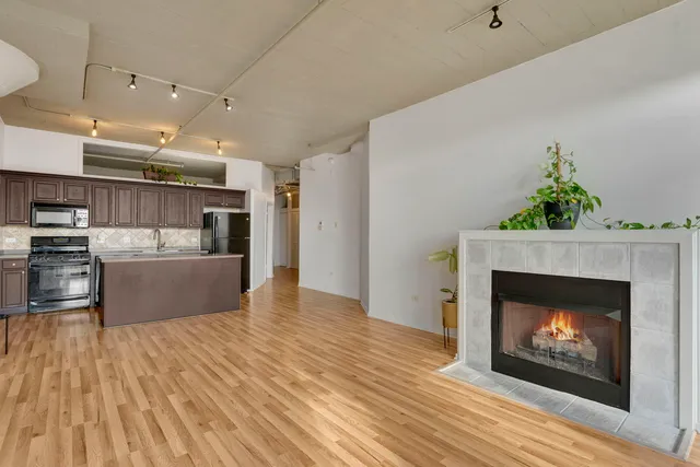 a open kitchen view with fireplace and wooden floor