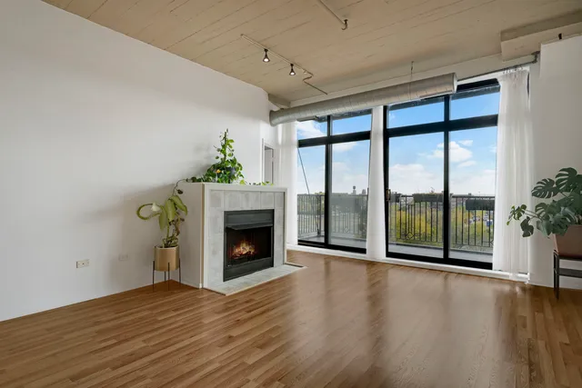 a view of empty room with wooden floor and fireplace