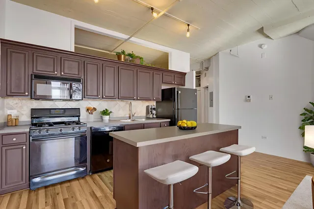 a kitchen with stainless steel appliances a stove a sink dishwasher and a refrigerator