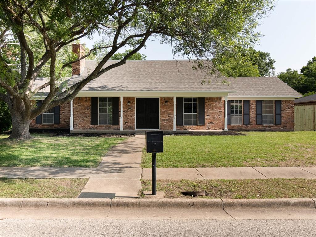 a front view of a house with a garden and yard