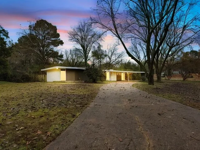 a front view of house with yard and trees around