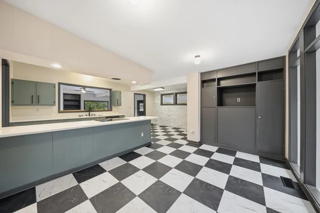 a room with a sink a mirror and cabinets