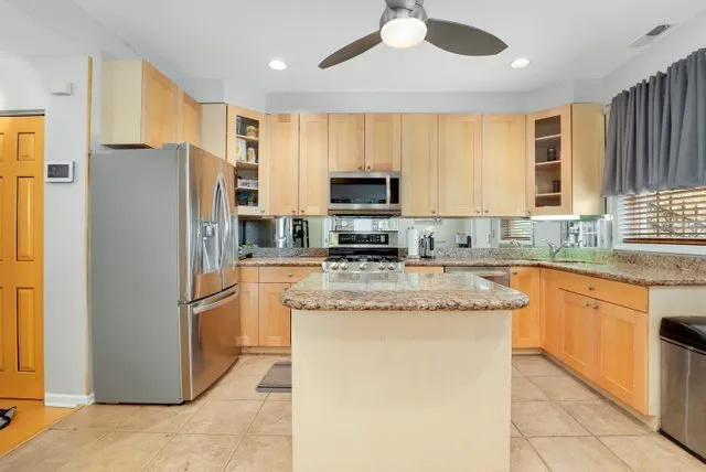a kitchen with granite countertop appliances a sink and a refrigerator