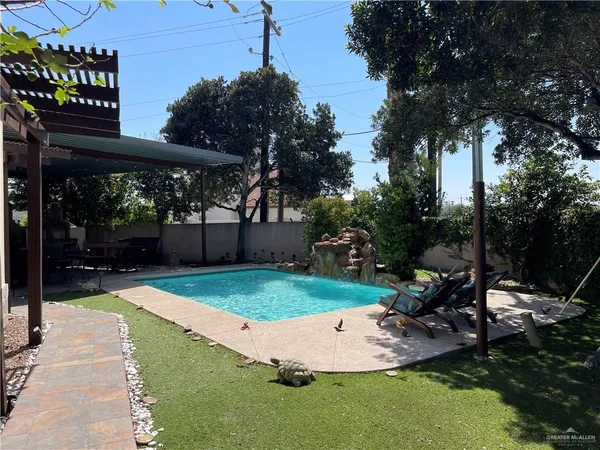 a view of a backyard with a table and chairs under an umbrella