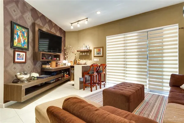 a living room with furniture kitchen view and a flat screen tv