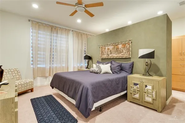 a bedroom with a large bed and a chandelier
