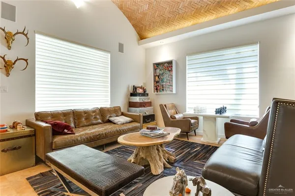 a living room with furniture two window and a dining table