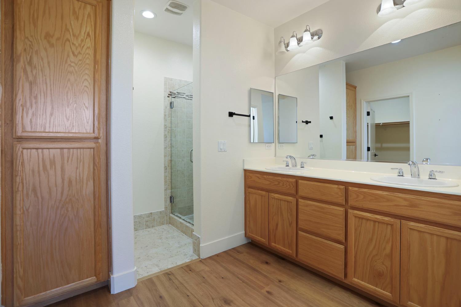 312 Copper Crest Drive Copperopolis, CA 95228 - Photo 16 of 38 a spacious bathroom with a double vanity sink a large mirror and shower