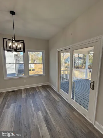 a kitchen with stainless steel appliances kitchen island granite countertop a stove a sink dishwasher a refrigerator and a wooden floor