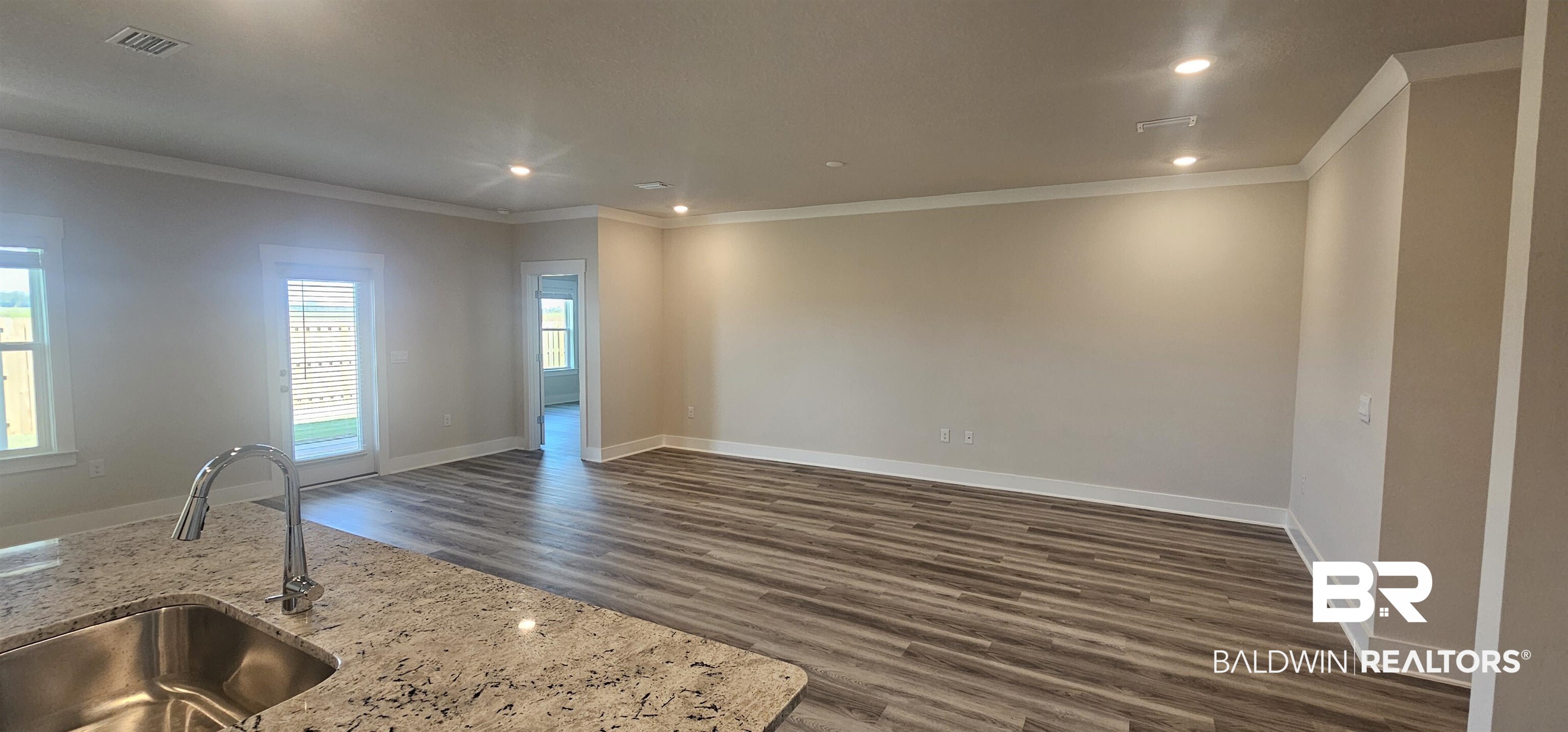 1045 Hayward Loop Foley, AL 36535 - Photo 3 of 12 Unfurnished living room with crown molding, dark wood-style floors, and recessed lighting